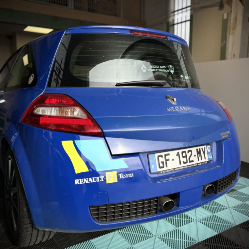 Renault Mégane RS bleue avec stickers Renault F1 Team sur le bouclier arrière