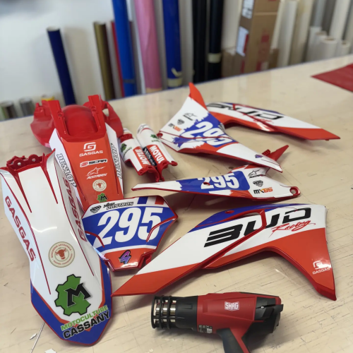 Pose d'un kit déco GasGas rouge, blanc et bleu au décapeur thermique