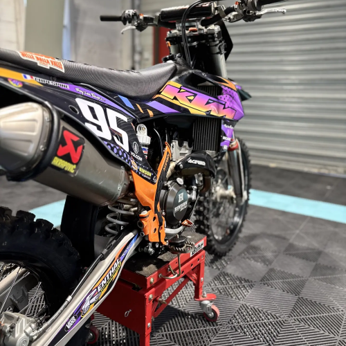Détail des stickers KTM violets et du numéro 95 sur le plastique arrière