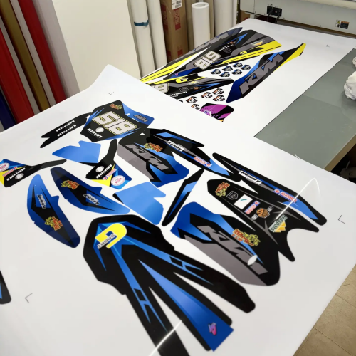 Impression d'un kit déco moto bleu sur imprimante grand format dans l'atelier