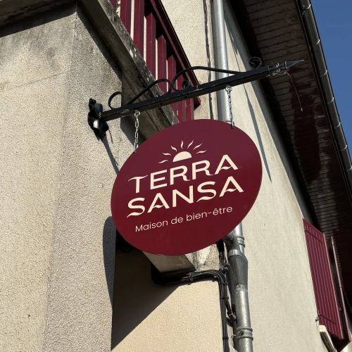 Enseigne drapeau ronde bordeaux Terra Sansa fixée en façade, Lot-et-Garonne
