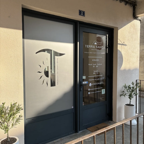 Adhésif dépoli avec logo découpé sur la porte vitrée de Terra Sansa, maison de bien-être