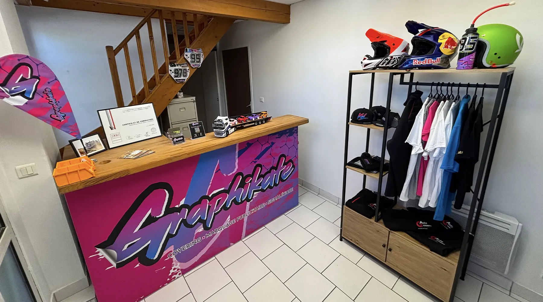 Devanture de l'atelier Graphikate avec enseigne, vitrophanie et drapeau publicitaire
