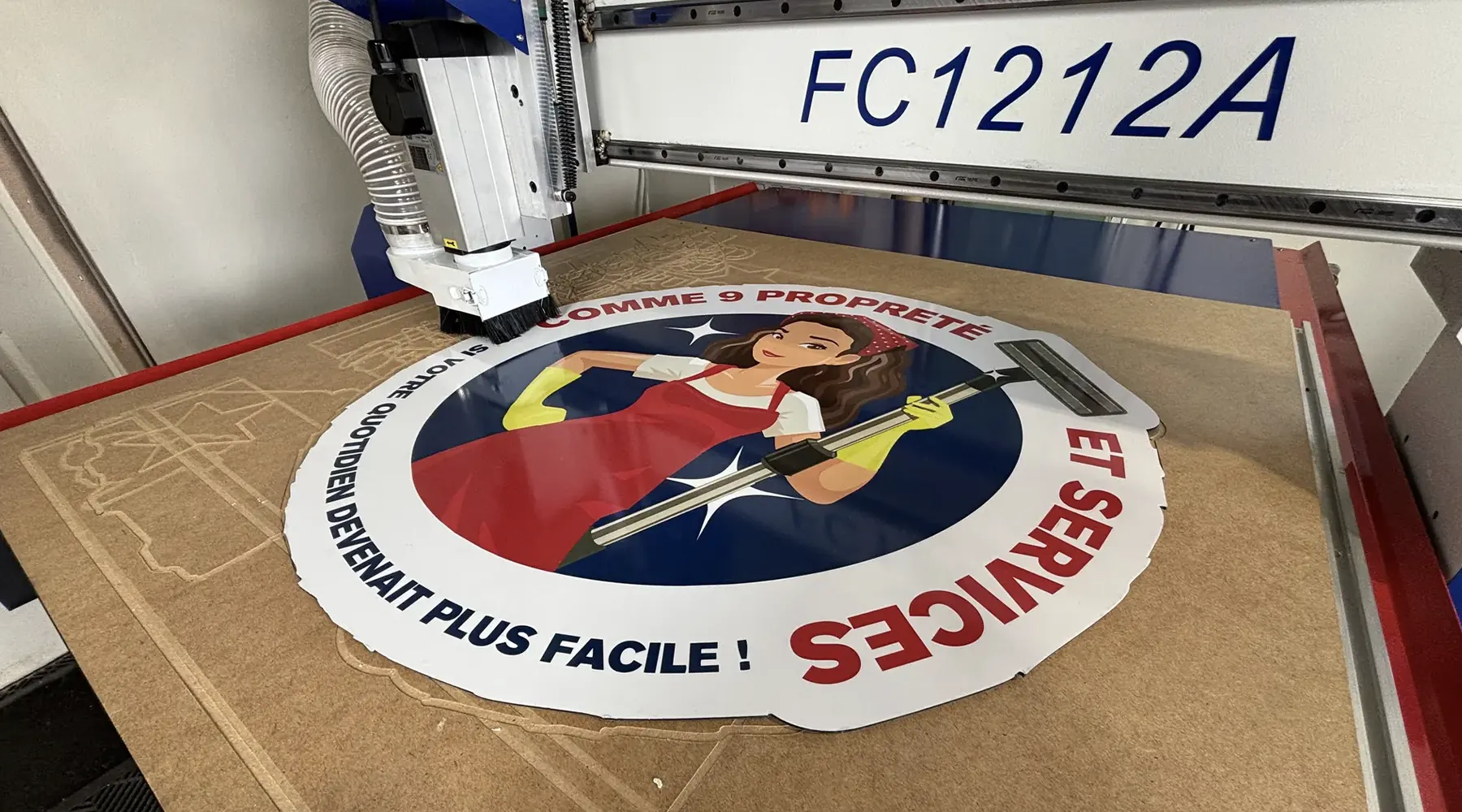 Machine à commande numérique découpant un panneau publicitaire à la forme chez Graphikate