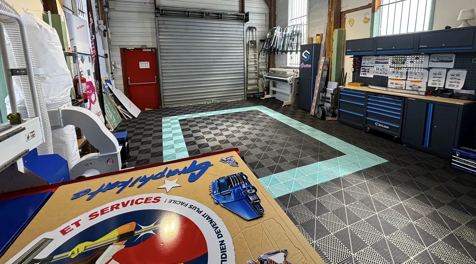 Espace de pose de l'atelier Graphikate avec panneau découpé à la forme en cours de fabrication